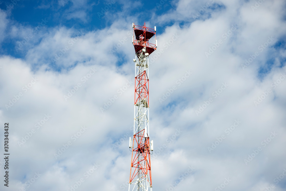 Obraz premium Telecommunication tower with blue sky and white clouds. Antenna on blue sky. Communication technology. Mobile or telecom 5g network. Technology