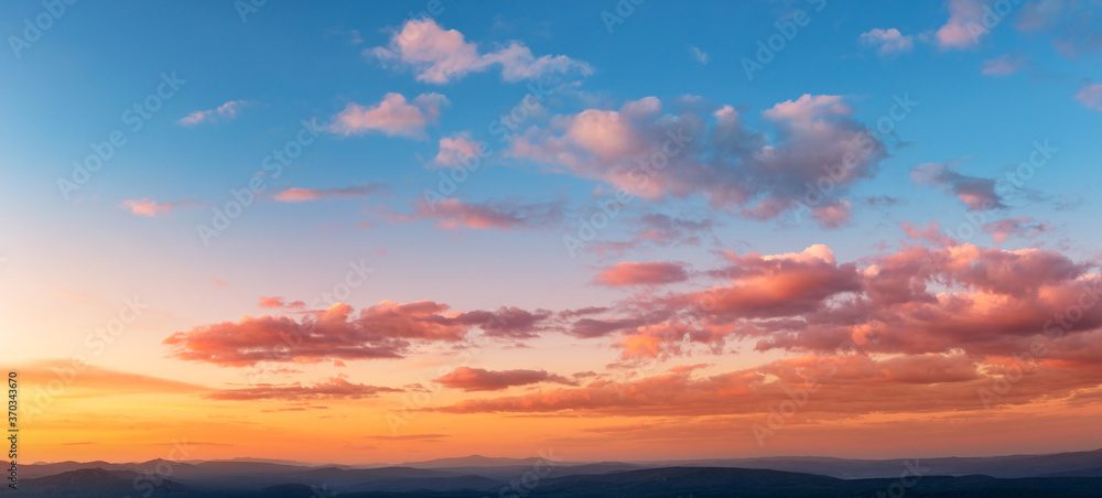 Sunset sky with clouds and red reflections from the sun. Bright colorful background
