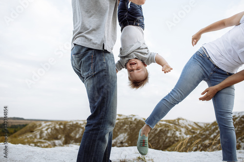 Mom, dad hugging son in the sand mountains enjoy and look at nature. Young family spending time together on vacation, outdoors. The concept of family summer holiday. Mother's, father's, baby's day.