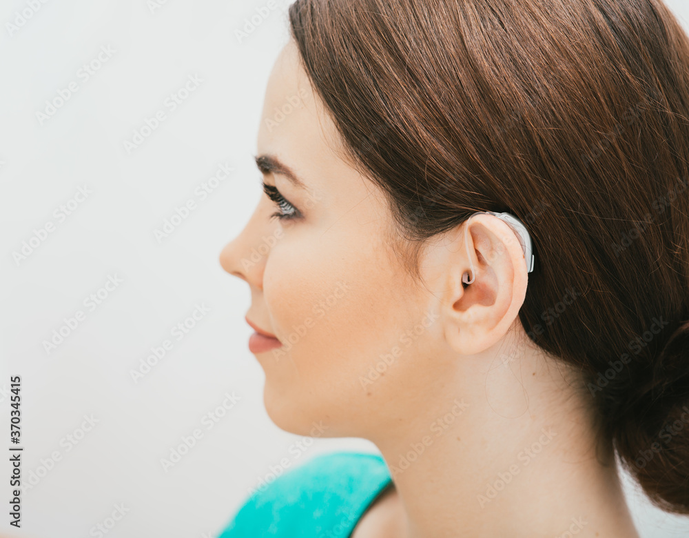 BTE hearing aid on female ear. Deafness treatment, hearing solution BTE hearing aid on female ear. Deafness treatment, hearing solution