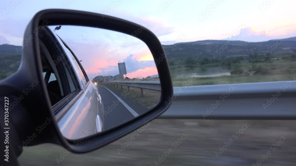Driving by Rearview Mirror at Sunset, Road Traffic, Pov Tracking Car on Highway, Auto Window View Driving by Rearview Mirror at Sunset, Road Traffic, Pov Tracking Car on Highway, Auto Window View