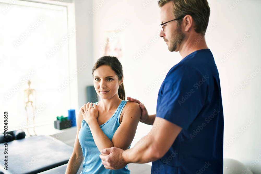 Obraz premium Male Physical Therapist Stretching a Female Patient