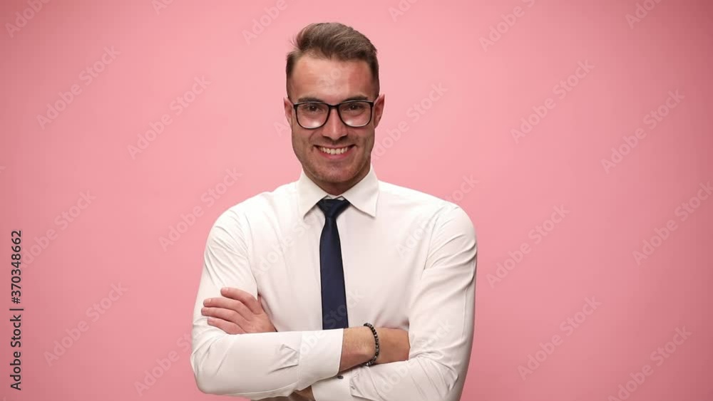 happy elegant guy in white shirt wearing glasses smiling, folding arms and pointing fingers on pink background happy elegant guy in white shirt wearing glasses smiling, folding arms and pointing fingers on pink background