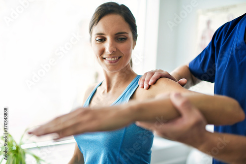 Male Physical Therapist Stretching a Female Patient Slowly. photo