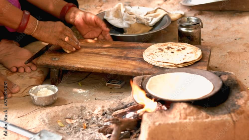 Female making Indian Bread ( rotis )on stove in Gujarat India