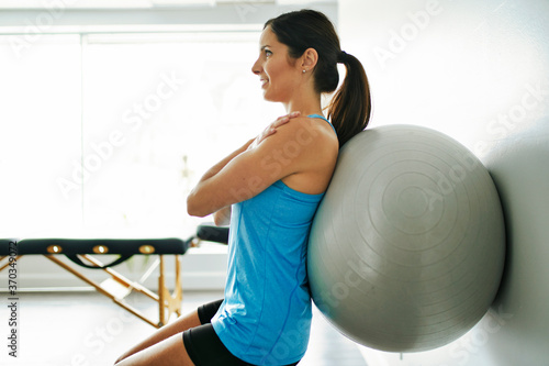 young woman doing exercise on fitness ball at the physiotherapy office photo