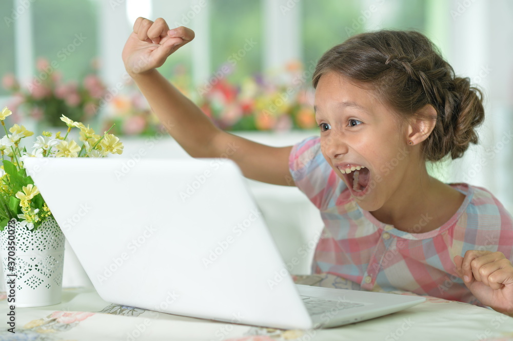 Emotional happy cute girl using laptop at home Emotional happy cute girl using laptop at home