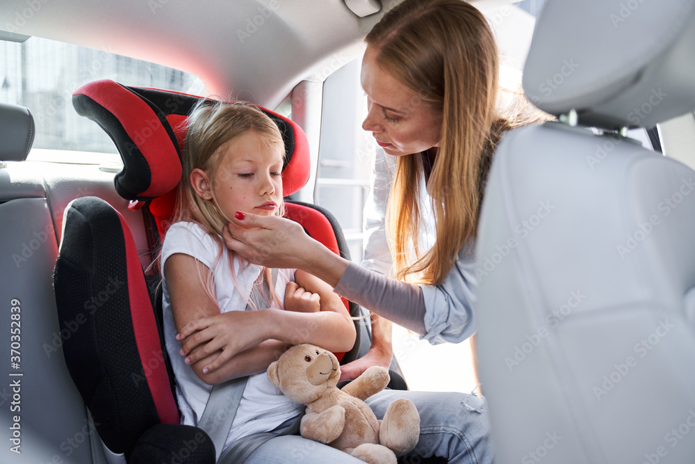 Mother taking care of child in car