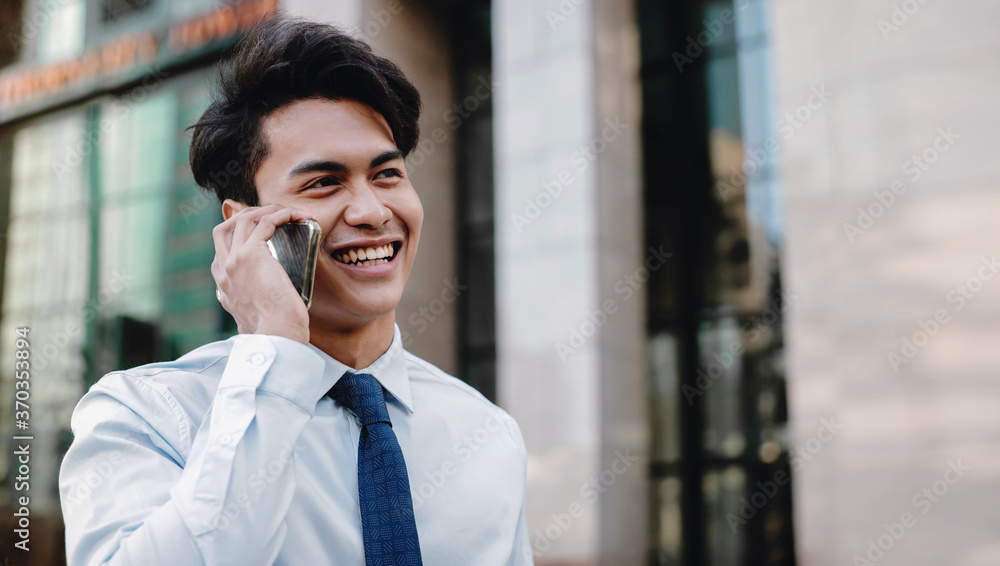 Portrait of a Happy Smiling Businessman Talking on Mobile Phone in the Urban City. Lifestyle of Modern People. Modern Building as background Portrait of a Happy Smiling Businessman Talking on Mobile Phone in the Urban City. Lifestyle of Modern People. Modern Building as background
