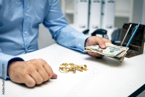 Man buying gold jewellry, pawn shop and us dollars Fototapet