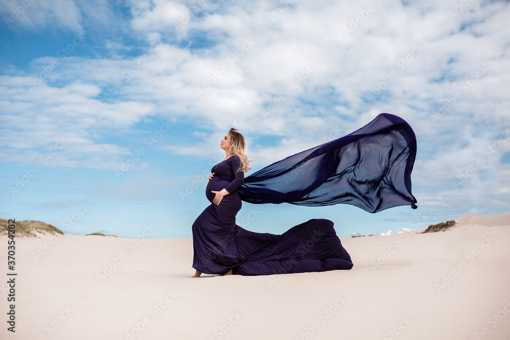 pregnant woman in a long dress in the desert. New life, new horizons and opportunities concept