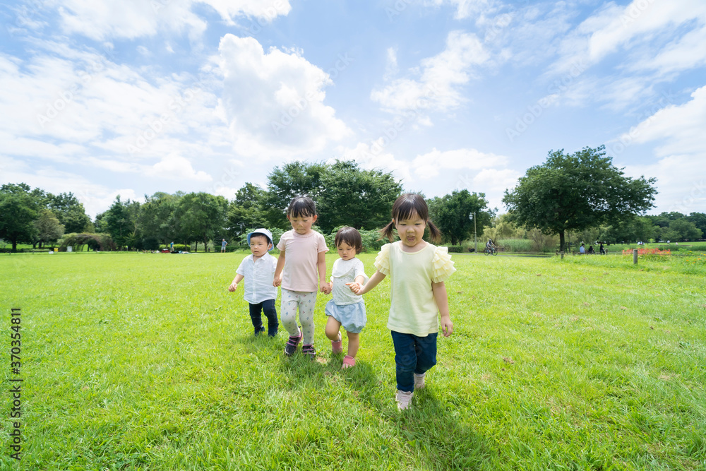 青空の下、手を繋いで元気に歩く子供たち