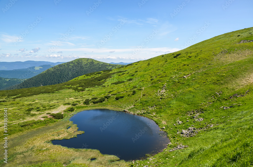 View from the height to Nesamovyte lake under hill among a green mountains. Carpathian mountains landscape 