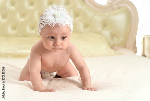 Portrait of cute little baby girl on bed