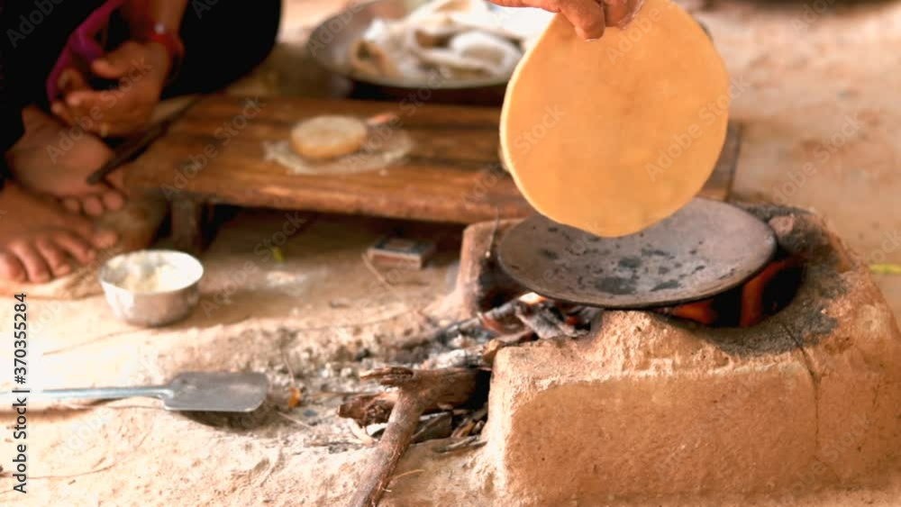 Female making Indian Bread ( rotis )on stove in Gujarat India, traditional indian food roti or Chapati, selective focus,Traditional way of making indian Roti or chapati in indian outdoor, Female making Indian Bread ( rotis )on stove in Gujarat India, traditional indian food roti or Chapati, selective focus,Traditional way of making indian Roti or chapati in indian outdoor,