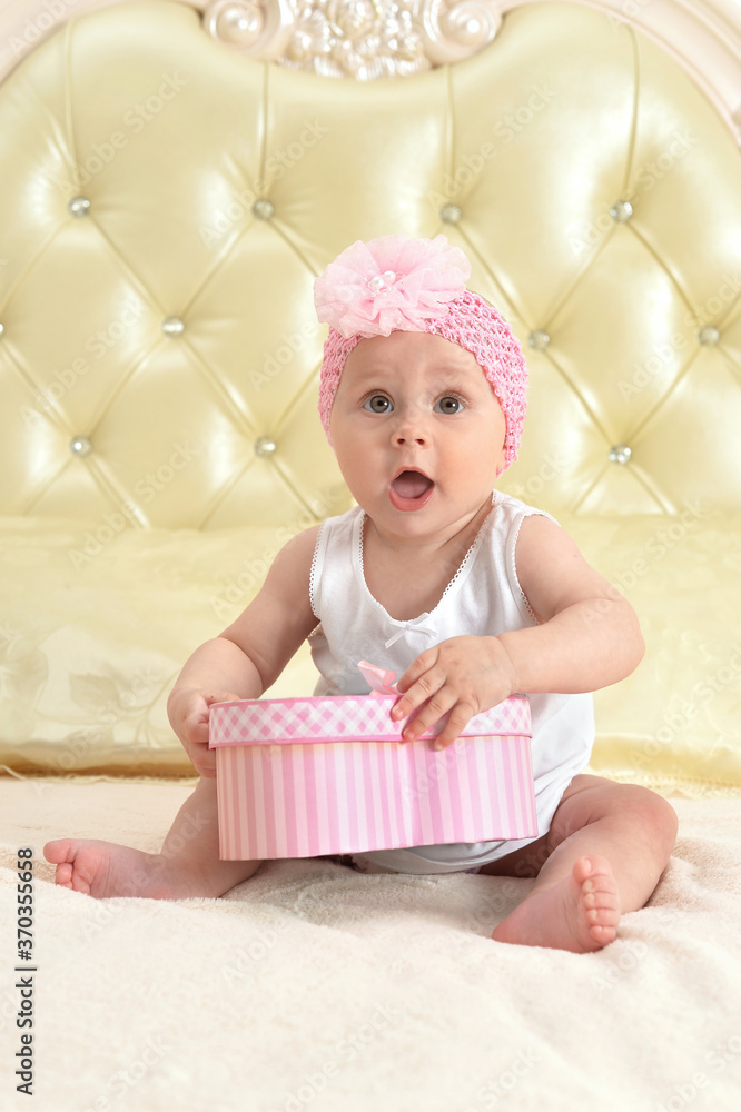 Cute little baby girl with gift on bed Cute little baby girl with gift on bed