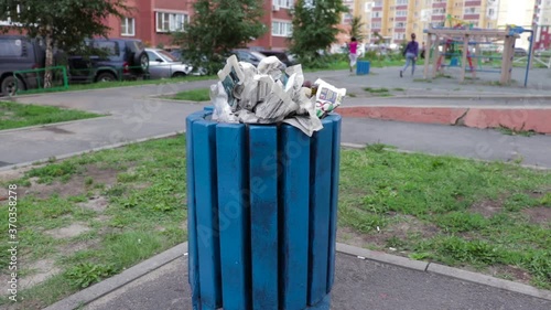 Trash can on the playground. The wind moves paper trash, video