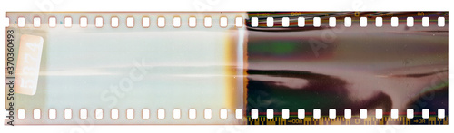 Start or beginning of 35mm negative film strip, first frames on white background, real scan of film material with shiny bright scanning light interferences.
