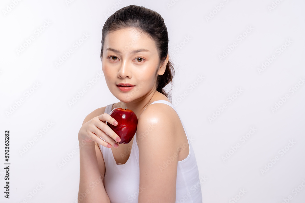 Beautiful young woman with clean fresh skin . She holds an apple. Facial treatment . Cosmetology , beauty and spa . Skin care Beautiful young woman with clean fresh skin . She holds an apple. Facial treatment . Cosmetology , beauty and spa . Skin care