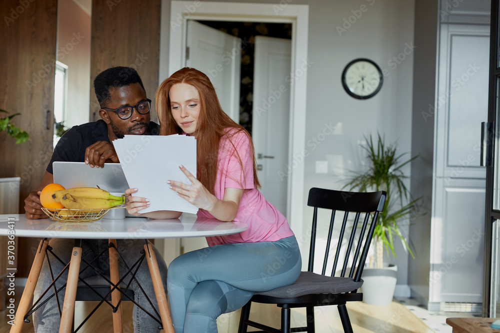 lovely diverse man and woman check documents, discuss their plans and have conversation about mortgage or loan lovely diverse man and woman check documents, discuss their plans and have conversation about mortgage or loan