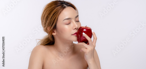 Beautiful young woman with clean fresh skin . She holds an apple. Facial treatment . Cosmetology , beauty and spa . Skin care