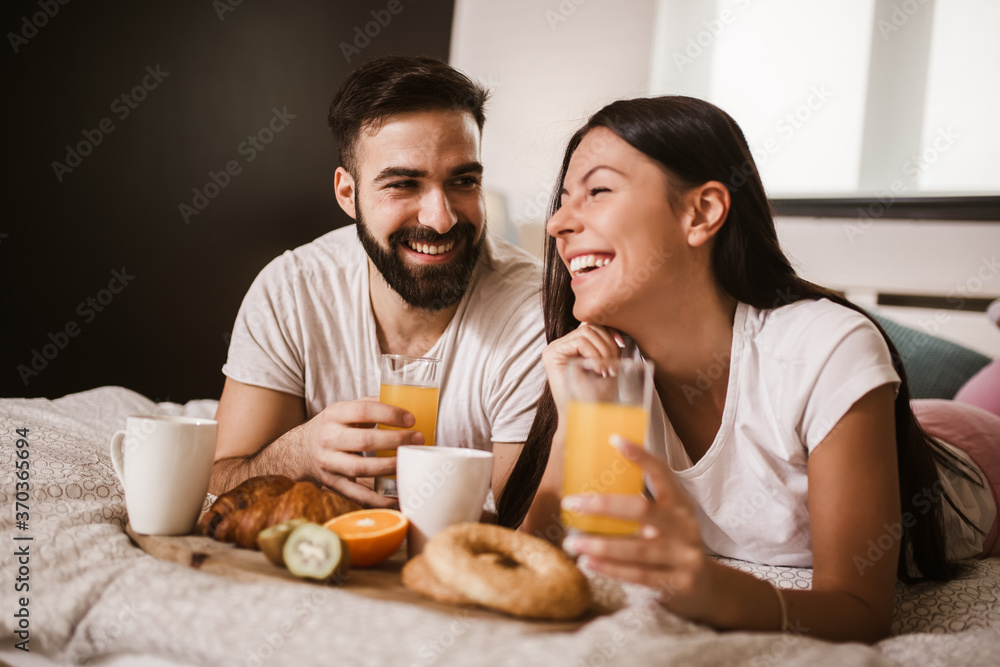 Cute couple having breakfast in bed in the bedroom Cute couple having breakfast in bed in the bedroom