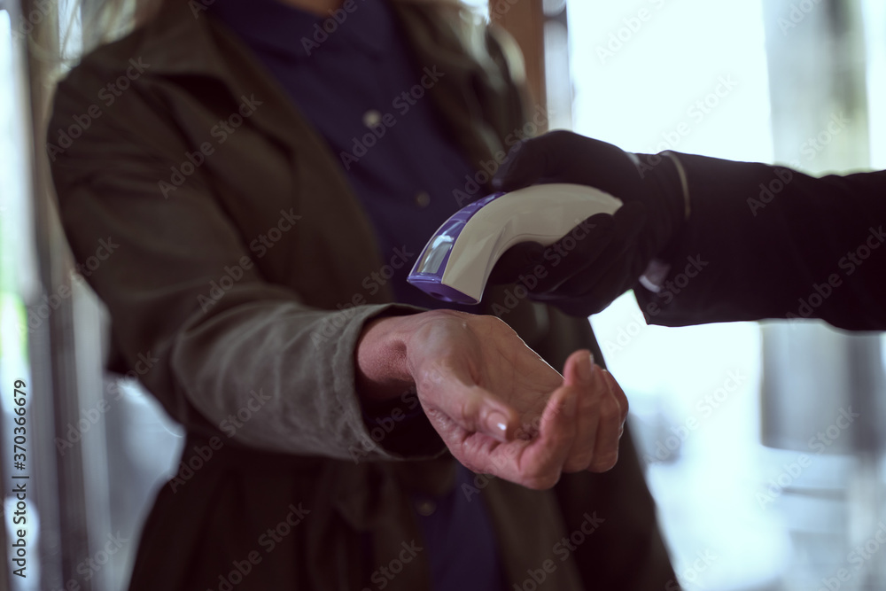 Female traveller having her temperature checked with a contactless thermometer Female traveller having her temperature checked with a contactless thermometer