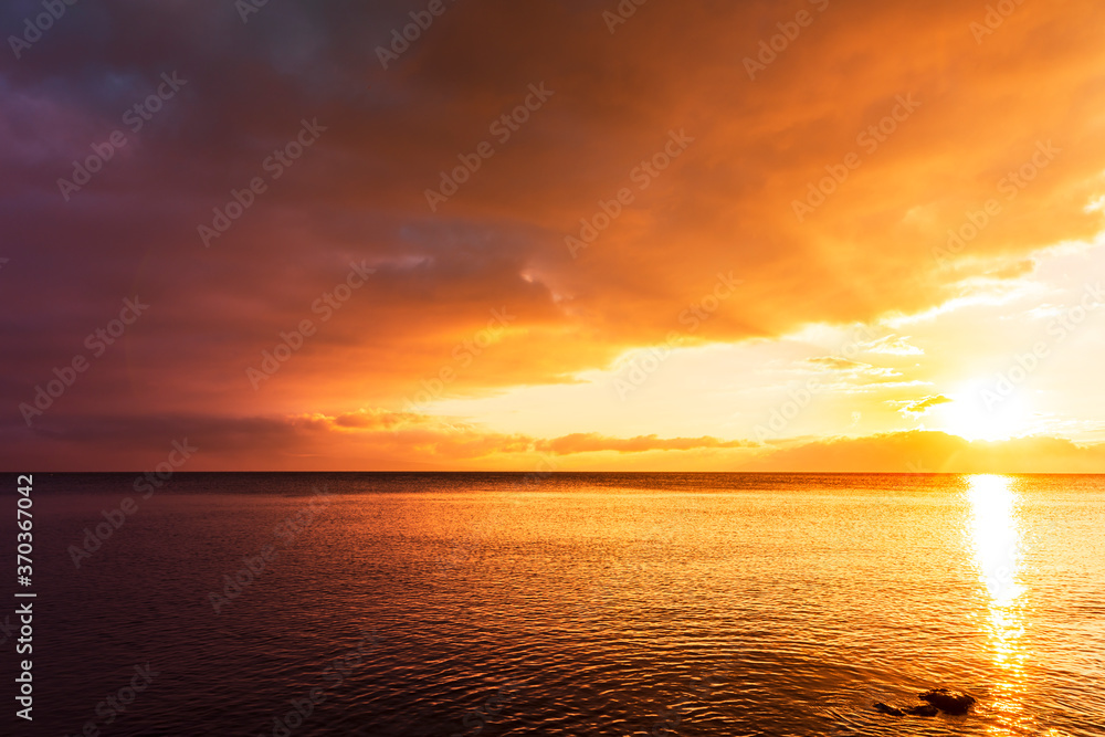 Beautiful landscape. Bright golden sunset with dramatics clouds over the lake. 