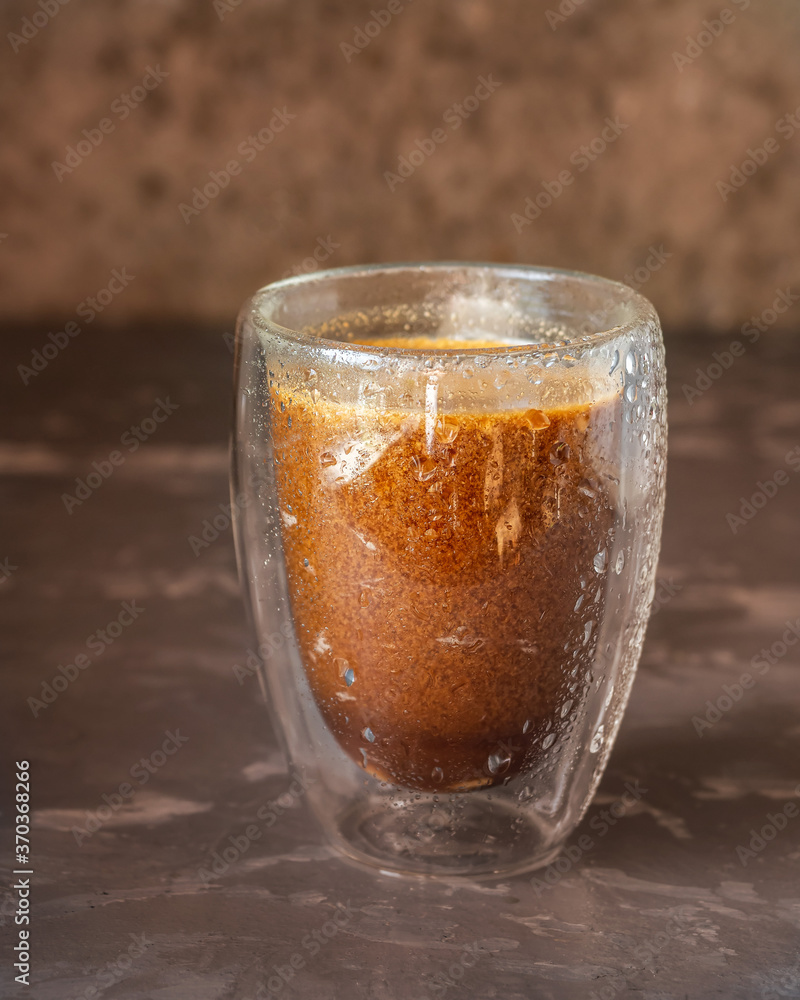 Coffee with cream in a tall glass thermostat close-up Coffee with cream in a tall glass thermostat close-up