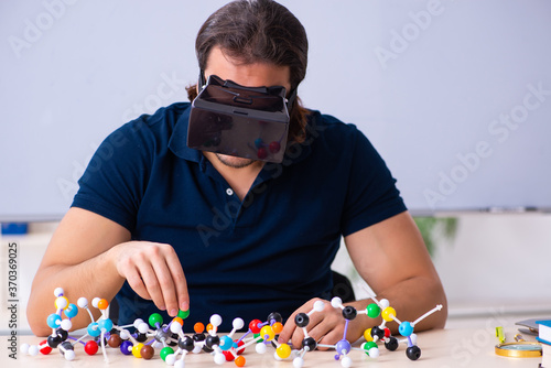 Картината върху платно Young male scientist sitting in the classroom