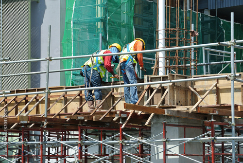 MALACCA, MALAYSIA -MARCH 25, 2016: Construction workers fabricating timber form work at the construction site in Malacca, Malaysia. The form work was mainly made from timber and plywood. 