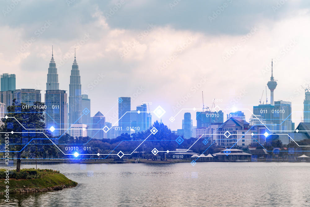 Obraz premium Glowing hologram of technological process, aerial panoramic cityscape of Kuala Lumpur at sunset. KL is the largest innovative hub of tech services in Malaysia, Asia. Multi exposure.