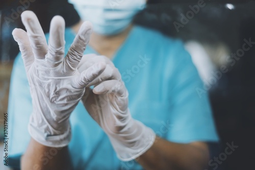 Close up doctor wearing gloves in surgery room.