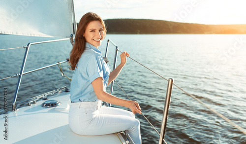 Joyful Lady Enjoying Yacht Ride Sitting On Deck Outside