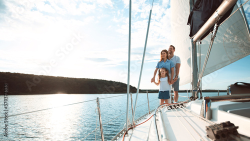 Parents And Daughter Standing On Yacht Sailing Across Sea, Panorama