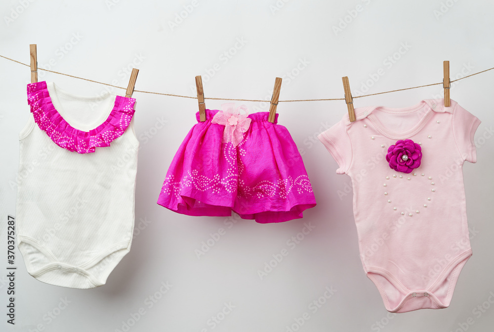 Baby clothes on a rope on a white background Baby clothes on a rope on a white background