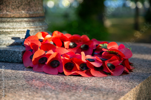 Φωτογραφία A red poppy wreath laid on a war memorial in remembrance of war dead