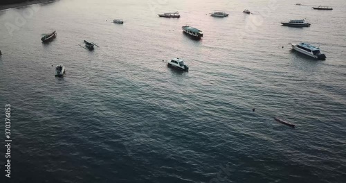 Looking down on a group of boats anchored in a bay in Indonesia in the evening before sunset photo