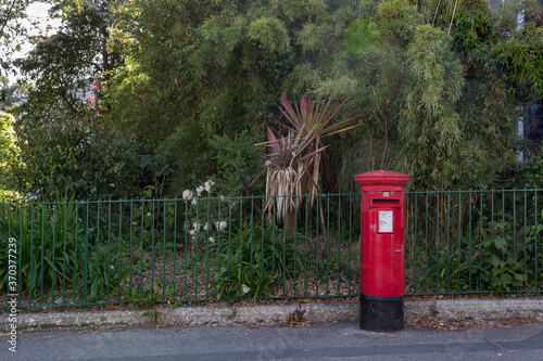 Red letter box outside public park in Penzance, Cornwall UK