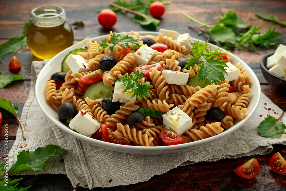 Pasta salad with tomato, black olives, cucumber and feta cheese in white plate. healthy food. Pasta salad with tomato, black olives, cucumber and feta cheese in white plate. healthy food.