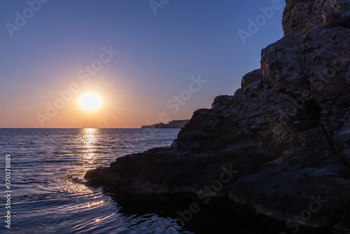 Rock in the sea at sunset