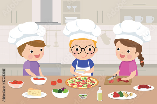 Happy children is cooking pizza in the kitchen. Kitchen interior with furniture on background.