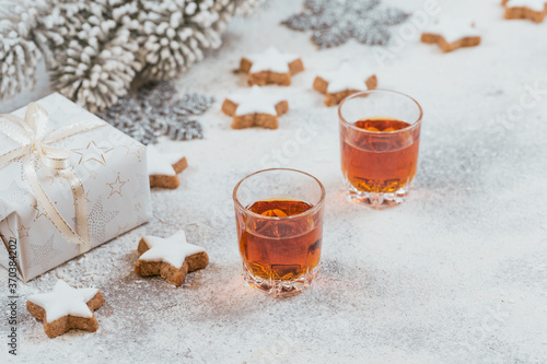 Two glasses of whiskey or bourbon, star cookies and decoration on white background
