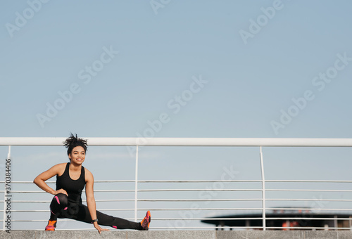 Gymnastics, pilates and fitness outdoors. African american girl in sportswear doing warm-up