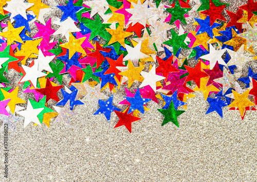 Background of multicolored stars on multicolored paper with sequins
