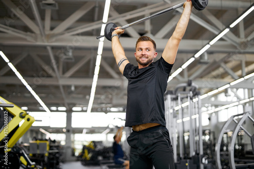 athletic caucasian bodybuilder working out, gaining weight pumping up muscles. healthy lifestyle, fitness and bodybuilding concept