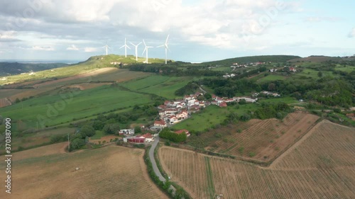 Flying forward to hillside village surrounded by Nature and Windmill´s as Background photo