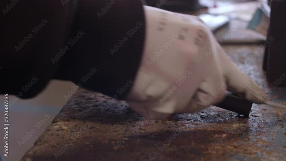 Hand closeup on a man filing metal bars, slowmotion Hand closeup on a man filing metal bars, slowmotion