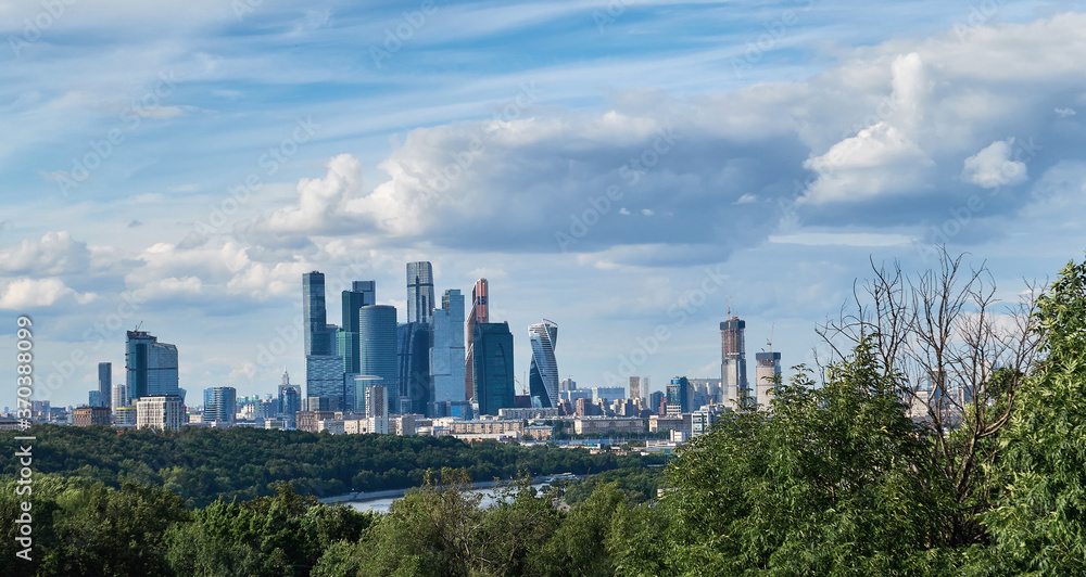 Fototapeta premium Skyscrapers with river reflections under cloudy sky in Moscow city district