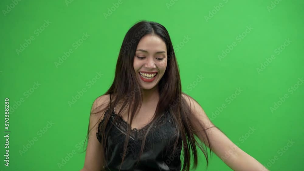 A beautiful Asian women dressed in black is dancing in a green screen
